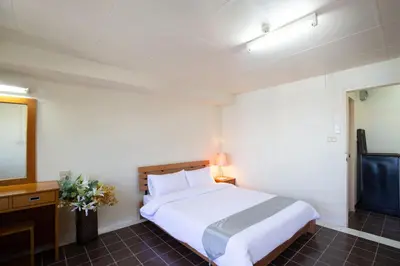 a bedroom with a white bed and a television at D haus Ngamwongwan Residence in Nonthaburi