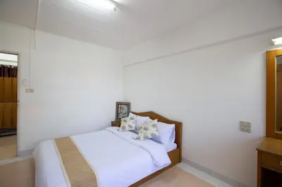 a bedroom with a bed with white sheets and pillows at D haus Ngamwongwan Residence in Nonthaburi