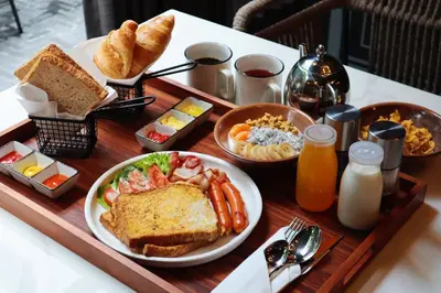 a breakfast tray with a plate of food and bread at PASSA Hotel Bangkok in Bangkok