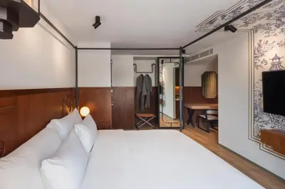 a bedroom with a large white bed with a mirror at PASSA Hotel Bangkok in Bangkok