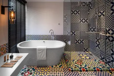 a bathroom with a tub and colorful tiles at PASSA Hotel Bangkok in Bangkok
