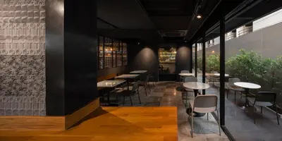 a restaurant with black walls and tables and chairs at PASSA Hotel Bangkok in Bangkok