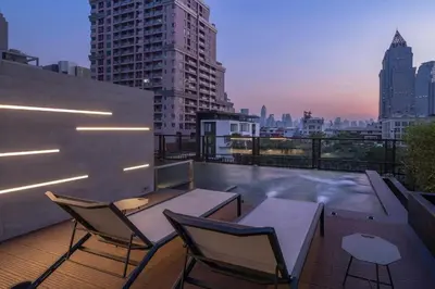 a rooftop patio with a table and chairs on a building at PASSA Hotel Bangkok in Bangkok