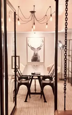 a dining room with a table and a picture of a deer at 3Howw Hostel @ Sukhumvit 21 in Bangkok