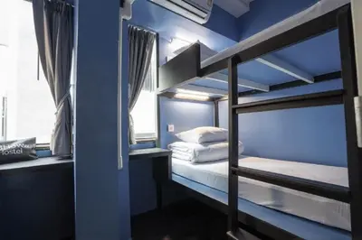 a room with two bunk beds and a blue wall at 3Howw Hostel @ Sukhumvit 21 in Bangkok