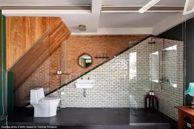 a bathroom with a staircase with a toilet and a sink at Ba Hao Residence in Bangkok