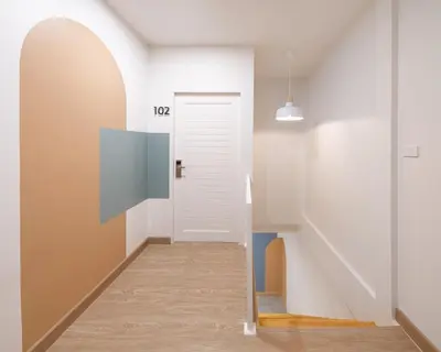 a hallway with a white door and stairs at COROOM BKK in Bangkok