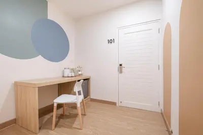 a desk with a chair in a room with a door at COROOM BKK in Bangkok