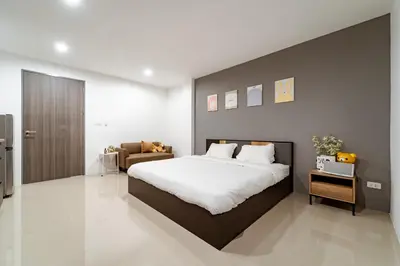 a bedroom with a large bed and a couch at My Space @ Chaosua69 in Ban Pak Khlong Khwang