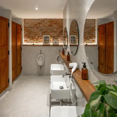 a bathroom with three sinks and a mirror at Tamni in Bangkok
