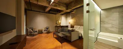a living room with a couch and a bed at 515 VICTORY Hotel in Pom Prap