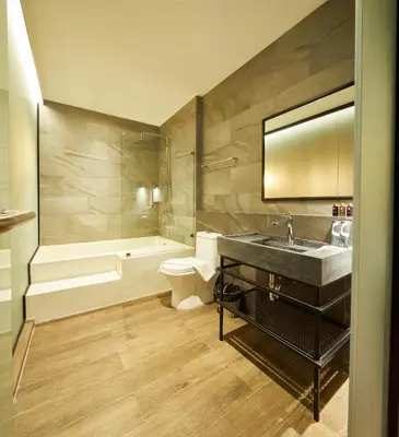 a bathroom with a sink and a tub and a toilet at 515 VICTORY Hotel in Pom Prap