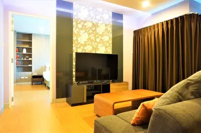 a living room with a couch and a television at Nest n Rest Hotel in Ban Bang Toei (1)