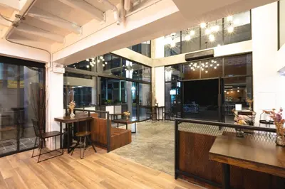 a lobby of a building with tables and chairs at WiRE BANGKOK PRAKHANONG in Amphoe Phra Khanong