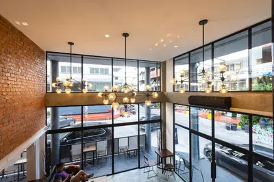 a large room with windows and a chandelier at WiRE BANGKOK PRAKHANONG in Amphoe Phra Khanong