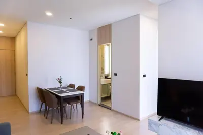 a dining room with a table and a tv at Wyndham Garden Bangkok Sukhumvit 42 in Bangkok