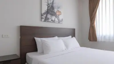 a bedroom with a bed with white sheets and a window at Pas Cher Hotel de Bangkok in Bangkok