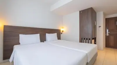 a bedroom with a large white bed with a wooden headboard at Pas Cher Hotel de Bangkok in Bangkok