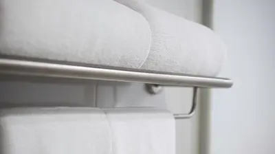 a stack of white towels on a towel rack at Pas Cher Hotel de Bangkok in Bangkok
