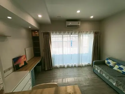 a living room with a couch and a window at Harmony family room in Bangkok
