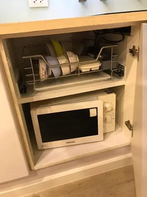 a microwave oven in a drawer in a cabinet at Harmony family room in Bangkok