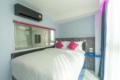a bedroom with a white bed with pink pillows at Spark Hotel - MRT Queen Sirikit - SHA Extra Plus Certified in Bangkok