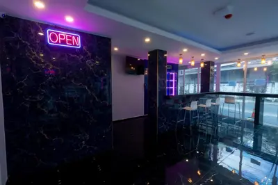 a restaurant with a neon open sign on the wall at Spark Hotel - MRT Queen Sirikit - SHA Extra Plus Certified in Bangkok