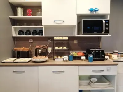a kitchen with a counter with food and a microwave at Beerapan Hotel in Bangkok