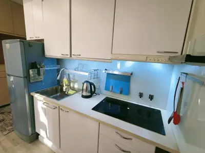 a kitchen with white cabinets and a sink and a refrigerator at \u6eab\u99a8\u5c0f\u5c4b in Bangkok