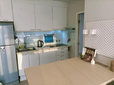 a kitchen with white cabinets and a table in it at \u6eab\u99a8\u5c0f\u5c4b in Bangkok