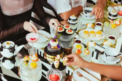 a group of people standing around a table with cupcakes at The Standard, Bangkok Mahanakhon in Bangkok