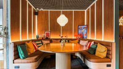 a dining room with a table and a couch at Gardina Asoke Hotel & Residence in Bangkok