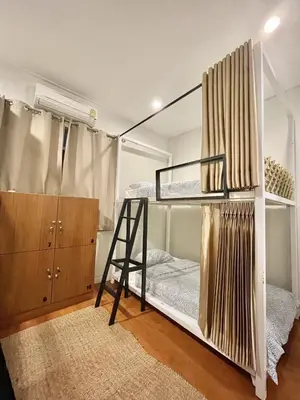 a room with two bunk beds and a ladder at Dara Three Hostel ดาราตรี in Bangkok
