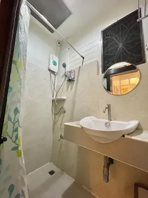 a bathroom with a sink and a shower at Dara Three Hostel ดาราตรี in Bangkok