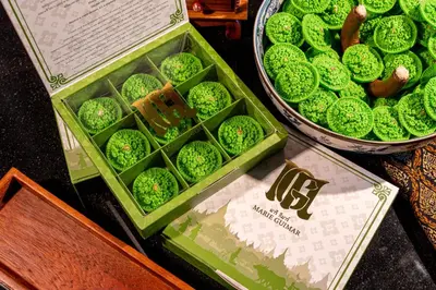 a display of green cookies in a basket and a sign at Wyndham Bangkok Queen Convention Centre in Bangkok