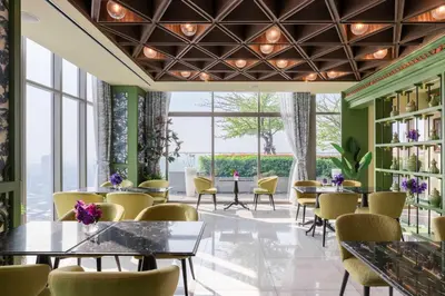 a restaurant with tables and chairs and large windows at Wyndham Bangkok Queen Convention Centre in Bangkok