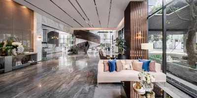 a living room with a white couch and blue pillows at Wyndham Bangkok Queen Convention Centre in Bangkok