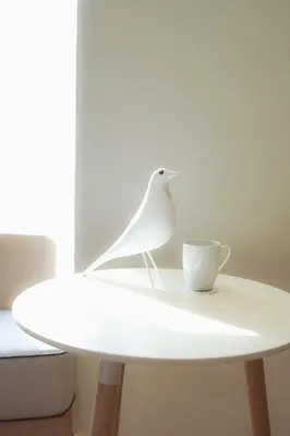 a white bird sitting on a white table with a cup at SQ Boutique Hotel in Bangkok
