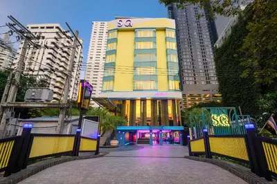 a yellow building with a ssi sign on it in a city at SQ Boutique Hotel in Bangkok