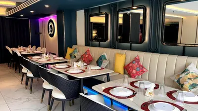 a row of tables in a restaurant with platesolitics at SQ Boutique Hotel in Bangkok