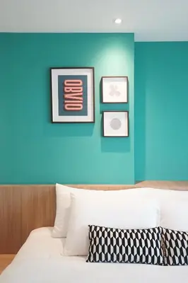 a bedroom with a blue wall and a white bed at SQ Boutique Hotel in Bangkok