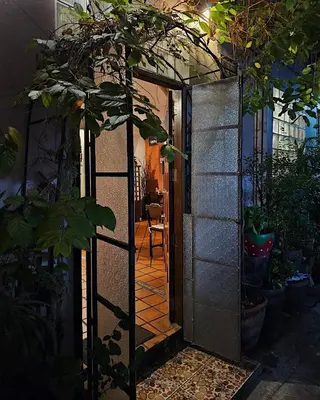 an open door to a room with a table at Baan Glang Soi Restaurant & Guesthouse in Bangkok