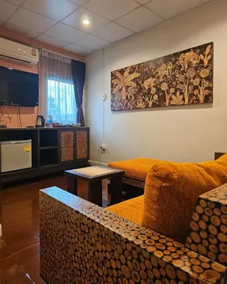 a living room with a couch and a tv at Baan Glang Soi Restaurant & Guesthouse in Bangkok