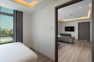 a mirror in a hotel room with a bed and a couch at ORION Hotel & Residence Bangna in Bangkok