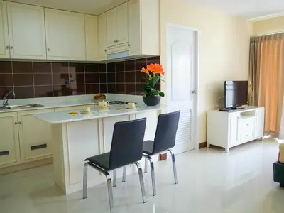 a kitchen with two chairs and a table and a counter at Charming Resident near BTS Ekkamai Station in Bangkok