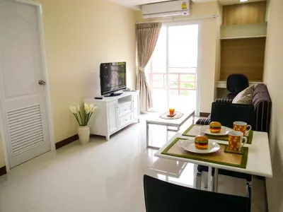 a living room with a table and a tv at Charming Resident near BTS Ekkamai Station in Bangkok