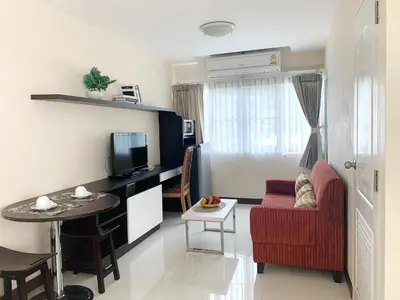 a living room with a red couch and a table at Charming Resident near BTS Ekkamai Station in Bangkok