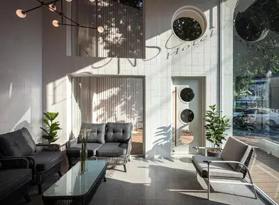 a living room with a couch and chairs and a table at Bonsai Hotel Bangkok in Bangkok