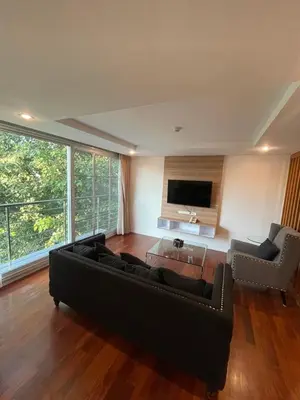 a living room with a black couch and a tv at ViVi Avenue Thonglor in Bangkok