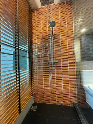 a bathroom with a shower with wooden blinds at ViVi Avenue Thonglor in Bangkok